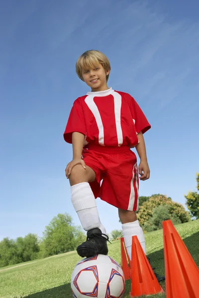 Pojke med foten på fotboll — Stockfoto