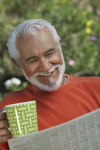 Счастливый пожилой человек, читающий газету — стоковое фото