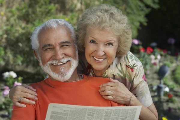 Портрет счастливой пожилой пары, читающей газету — стоковое фото