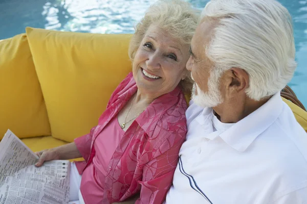 Ηλικιωμένο ζευγάρι χαλαρώνει δίπλα στην πισίνα — Φωτογραφία Αρχείου