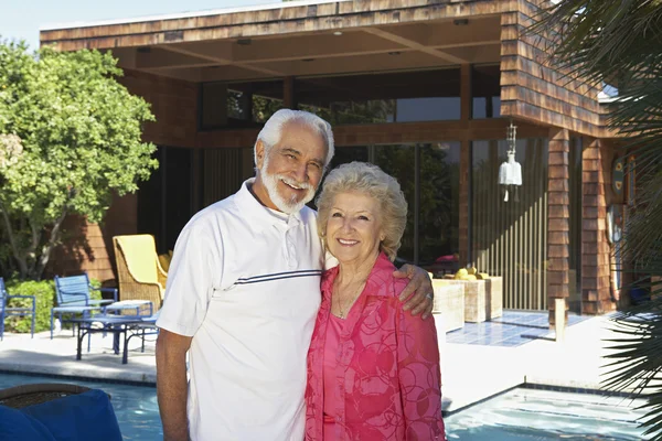 Старшая пара, стоящая снаружи дома — стоковое фото