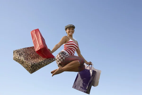 Femme sautant avec des sacs à provisions — Photo