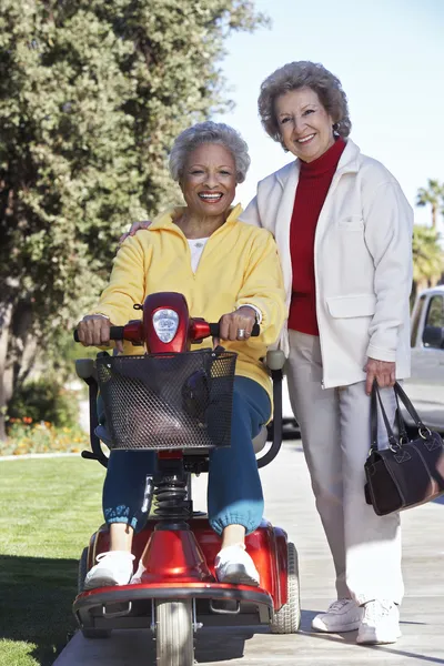 Anziano donna su motorino con amico — Foto Stock