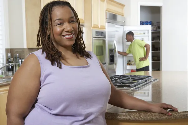 Mulher obesa feliz no balcão da cozinha — Fotografia de Stock