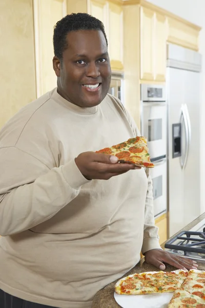 Hombre sosteniendo rebanada de pizza — Foto de Stock