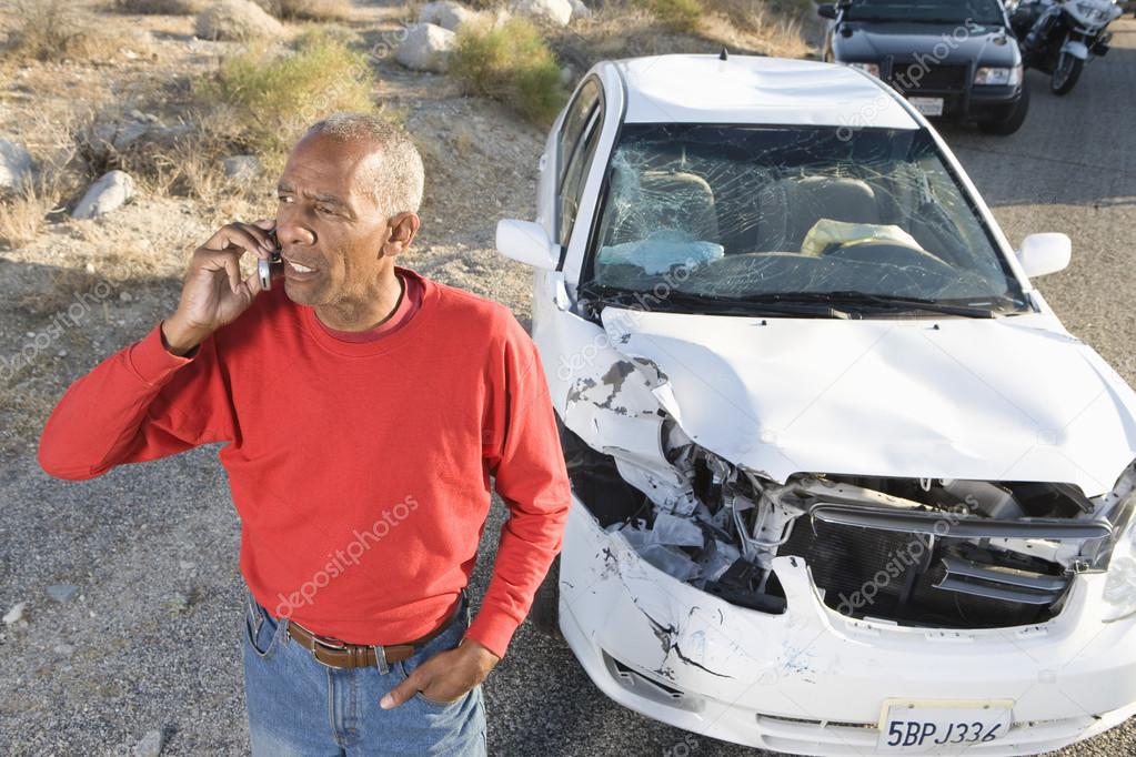 Senior Man On Call With Damaged Car In The Background