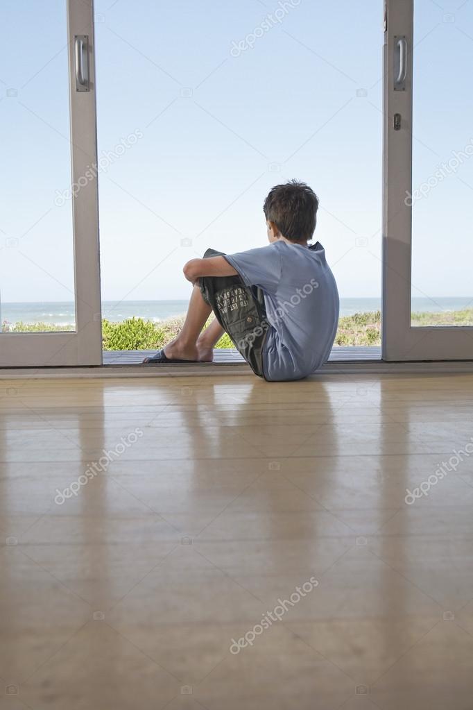 Boy Sitting In Doorway