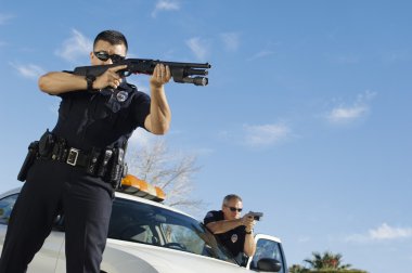 Police Officer Aiming Shotgun clipart