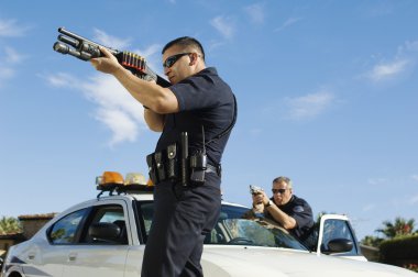 Polis memuru amaçlayan av tüfeği