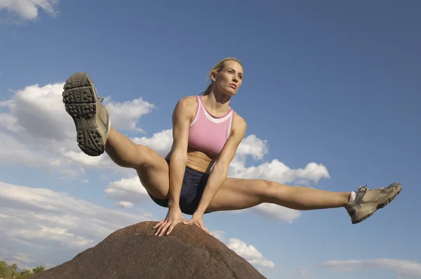 Молодая женщина балансирует на скале — стоковое фото