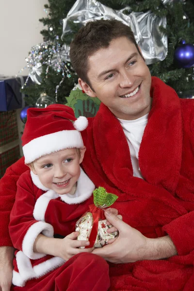 Padre e hijo en santa claus traje celebración presente — Foto de Stock