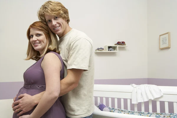 出産を控えたカップル クレードルを抱きしめる — ストック写真