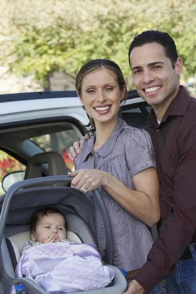 Happy Couple With Baby In Carrier — Stock Photo, Image