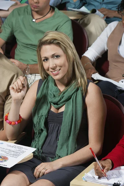 Femme étudiant tenant des lunettes dans la salle de classe — Photo