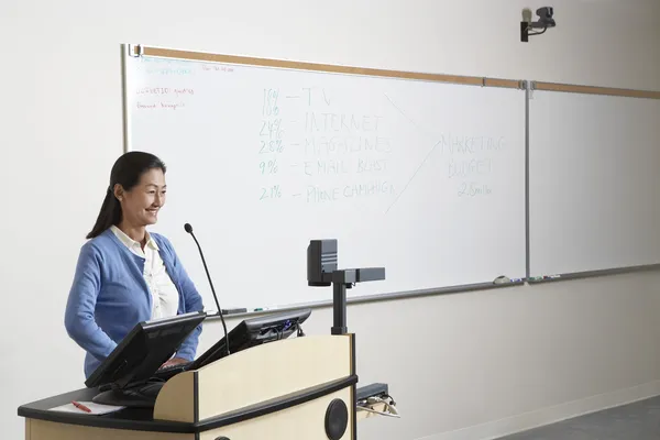 Profesora de pie en el podio — Foto de Stock