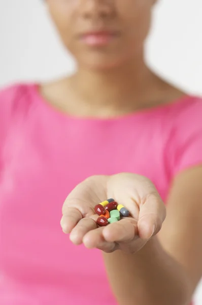 Mulher mostrando pílulas — Fotografia de Stock