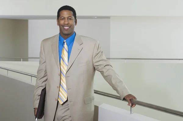 Biznes człowiek stojący przez balustrady w biurze — Zdjęcie stockowe