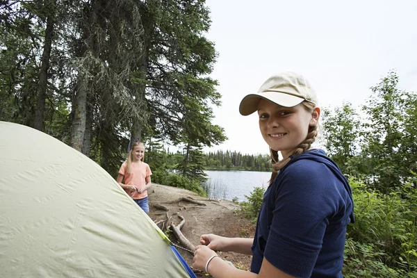Nastoletnich dziewcząt stojących namiot w pobliżu jeziora — Zdjęcie stockowe