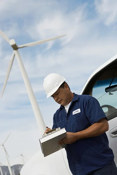 Ingenjör skriva Urklipp på wind farm — Stockfoto