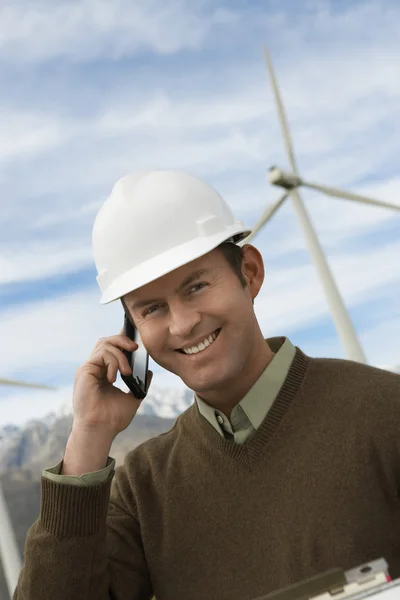 Ingenjör med mobiltelefon på wind farm — Stockfoto