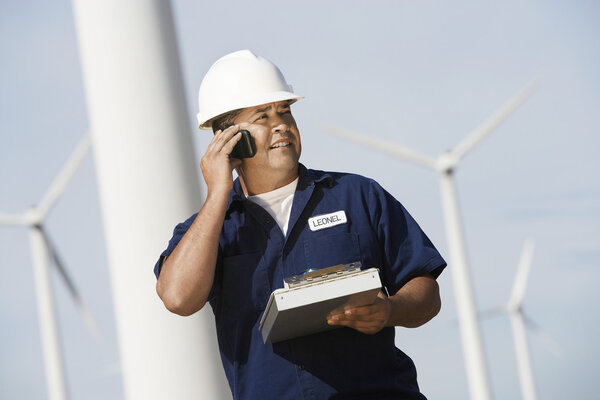 Engineer Using Cell Phone At Wind Farm