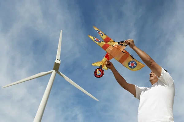 Mann hält Flugzeugdrachen an Windpark — Stockfoto