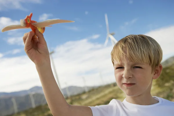 Pojke leker med leksak segelflygplan på wind farm — Stockfoto