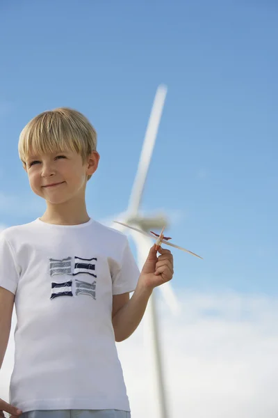 Jongen met speelgoed zweefvliegtuig op wind farm — Stockfoto