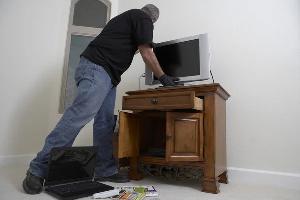 Cambrioleur volant la télévision de la maison — Photo