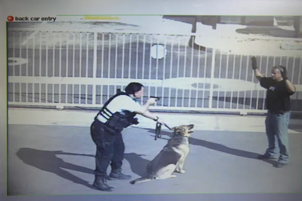 Security Guard Aiming Gun At Thief In Parking Lot — Stock Photo, Image