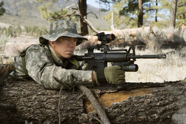 Soldier With Machine Gun Leaning On Log — Stock Photo, Image