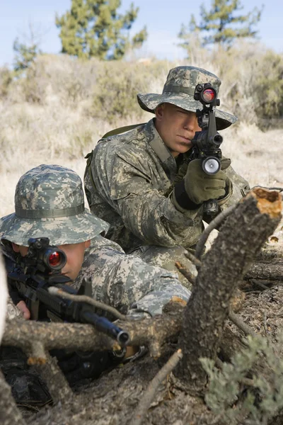 Soldats avec mitrailleuse penchés sur le rondin — Photo