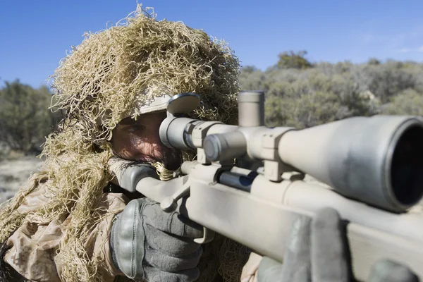 Soldado en césped camuflaje apuntando rifle —  Fotos de Stock