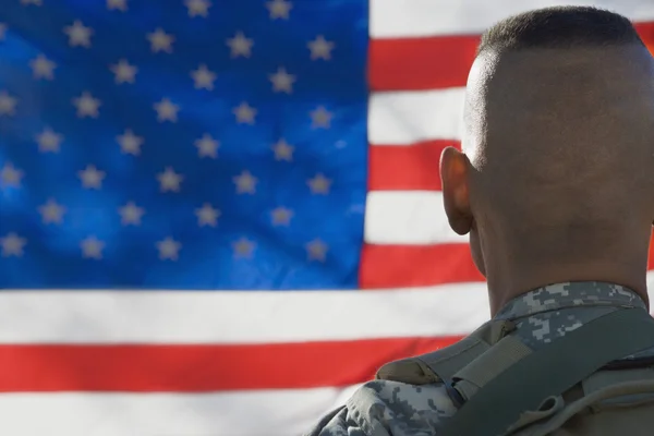 Soldado del ejército estadounidense mirando la bandera — Foto de Stock