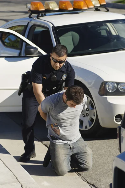 Oficial de policía arrestando a un joven — Foto de Stock