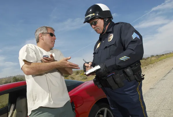Дорожный полицейский выписывает штраф — стоковое фото