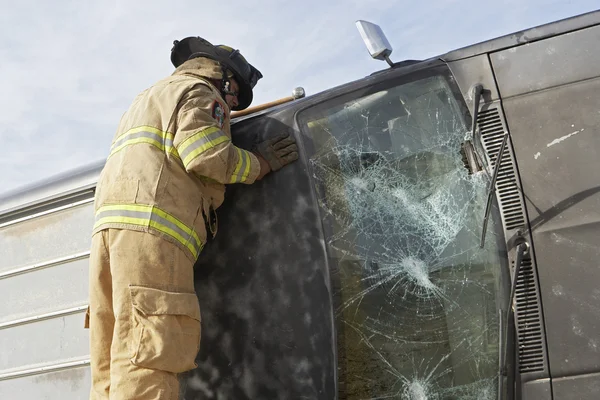 Bombero inspeccionando un coche estrellado —  Fotos de Stock