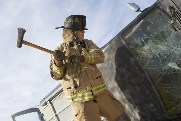Firefighter Hitting Crashed Car With Axe — Stock Photo, Image
