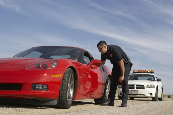 Kırmızı spor araba durduran trafik polisi — Stok fotoğraf