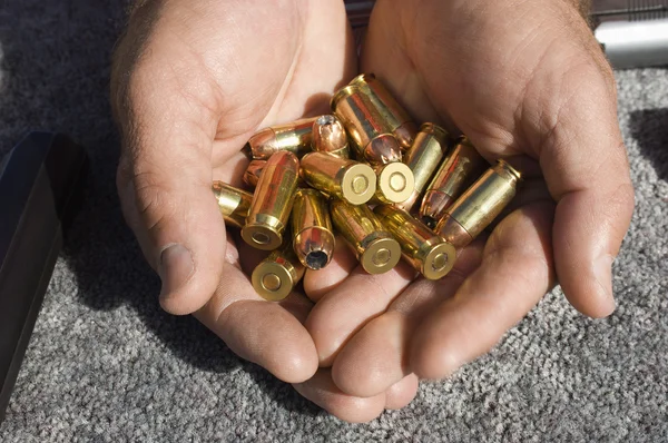Manos de hombre sosteniendo balas — Foto de Stock