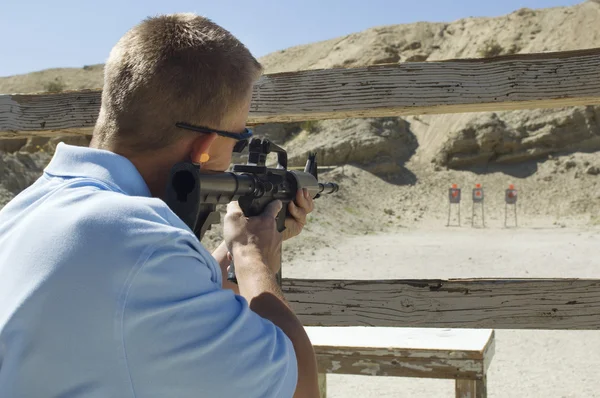 Hombre apuntando ametralladora en campo de tiro — Foto de Stock
