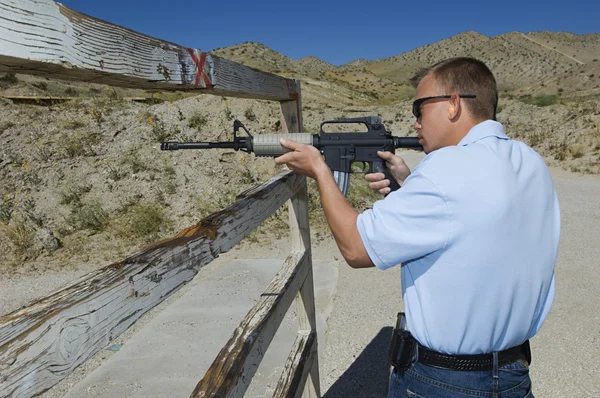 Un homme qui vise un fusil au champ de tir — Photo