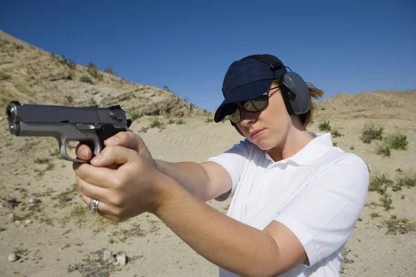 Woman Aiming Hand Gun At Firing Range In Desert — Stock Photo, Image