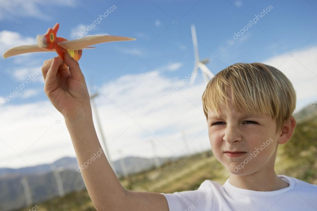 Boy Playing With Toy Glider At Wind Farm