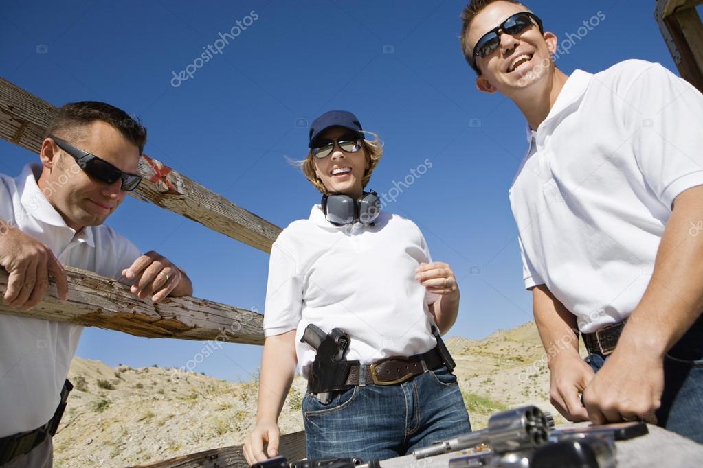 Men And Woman With Hand Guns At Firing Range