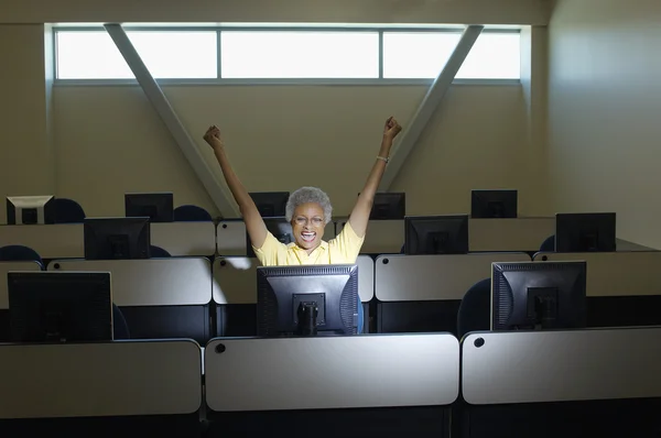 Professora sênior comemorando a vitória na sala de aula de informática — Fotografia de Stock