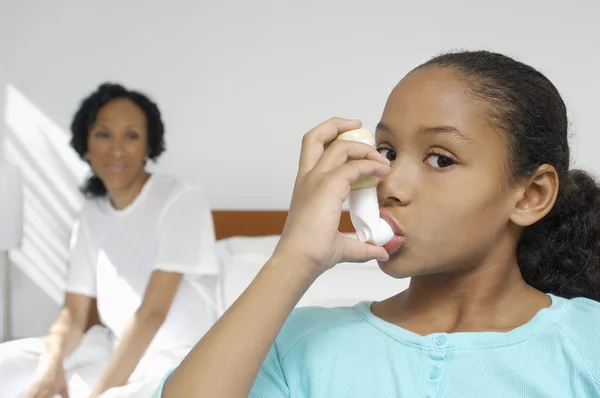 Flicka som använder astmainhalator — Stockfoto