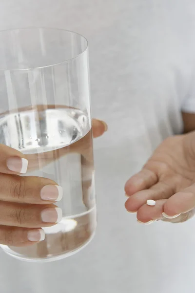 Gros plan des mains tenant pilule et verre d'eau — Photo