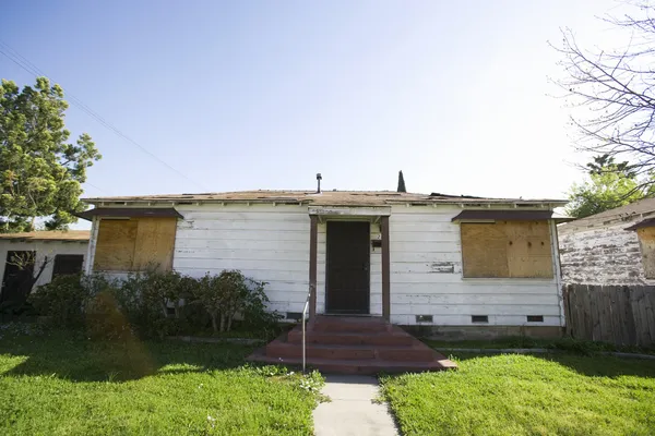 Casa abandonada con ventanas tapiadas — Foto de Stock