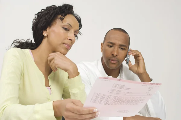 Pareja tratando con un proyecto de ley — Foto de Stock